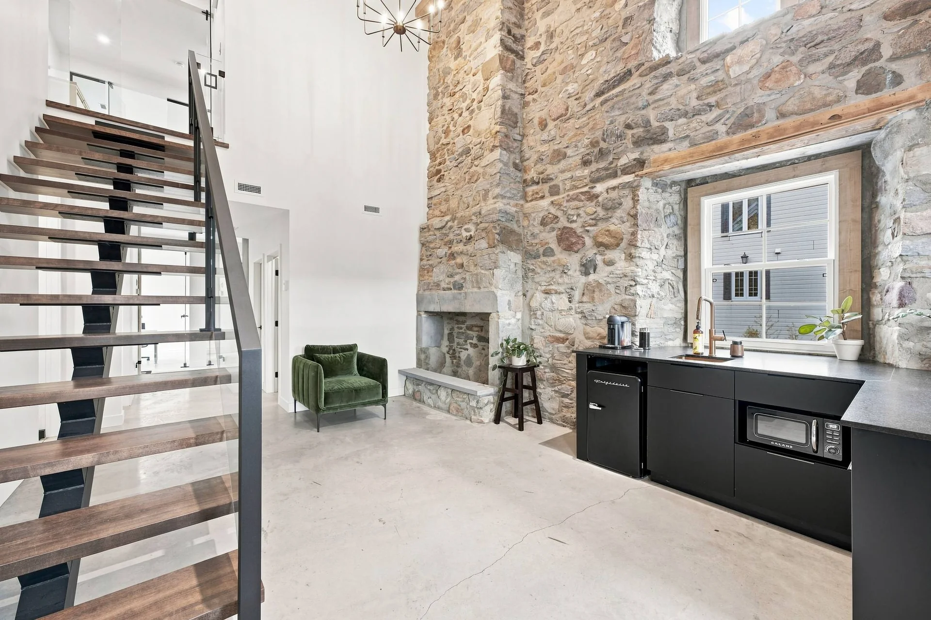 Le grand volume : mur de pierre sur toute la hauteur, escalier et foyer de pierre