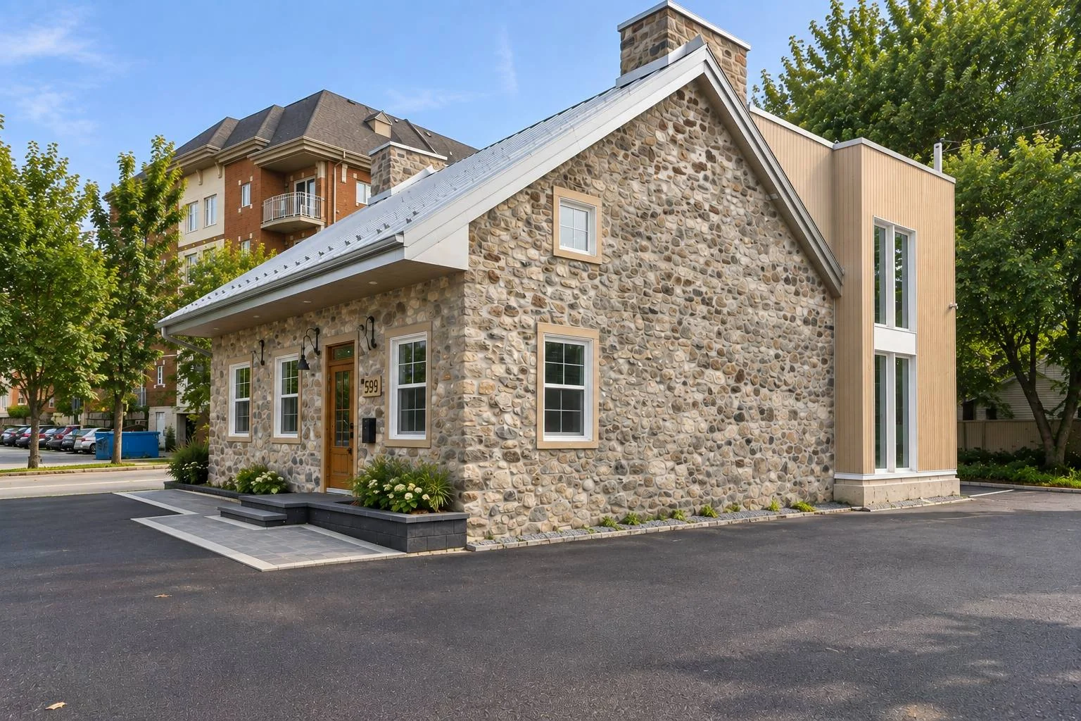 Le bâtiment de pierre et son agrandissement contemporain en bardage de bois, vus depuis la rue