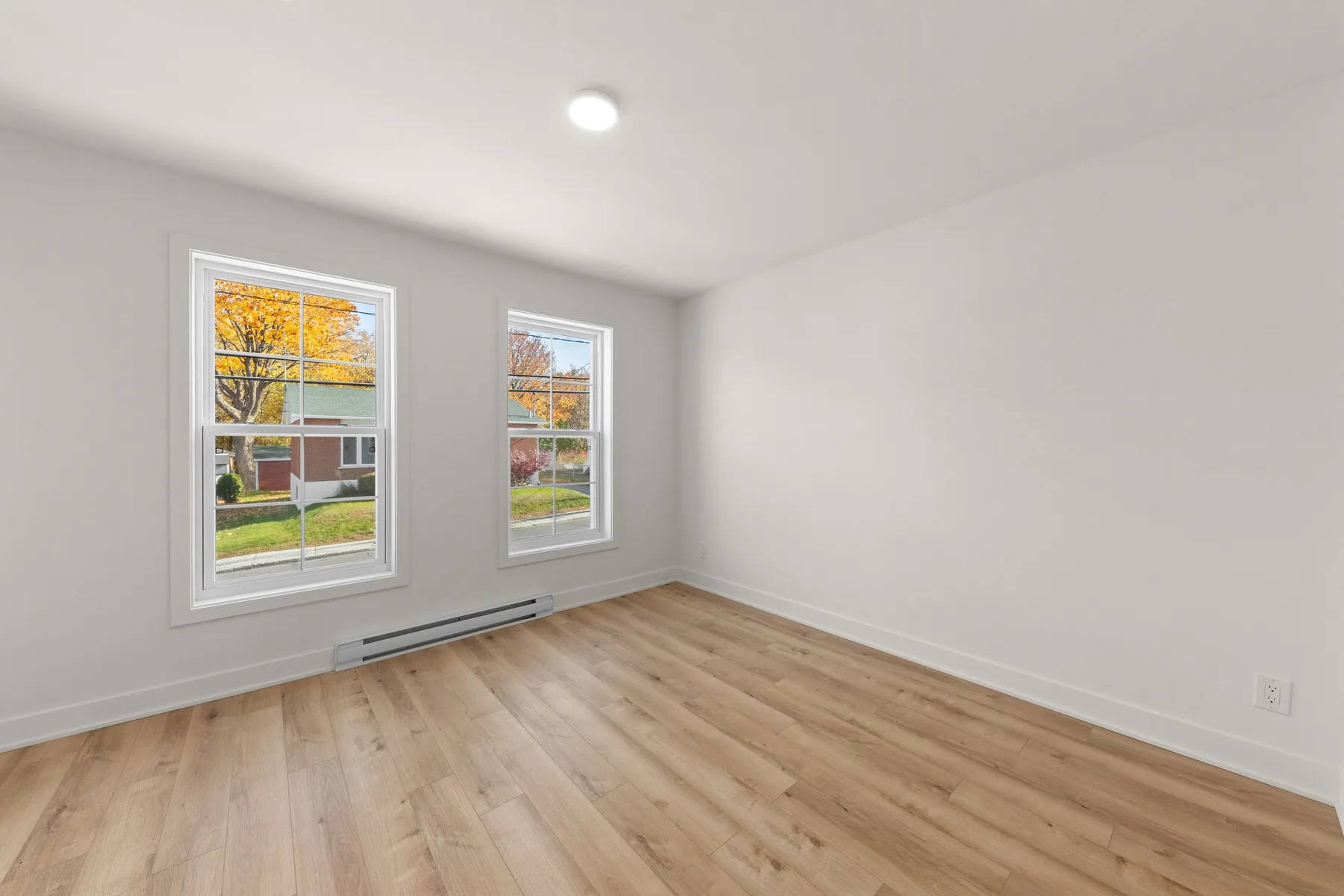 Une chambre et ses deux fenêtres sur le quartier