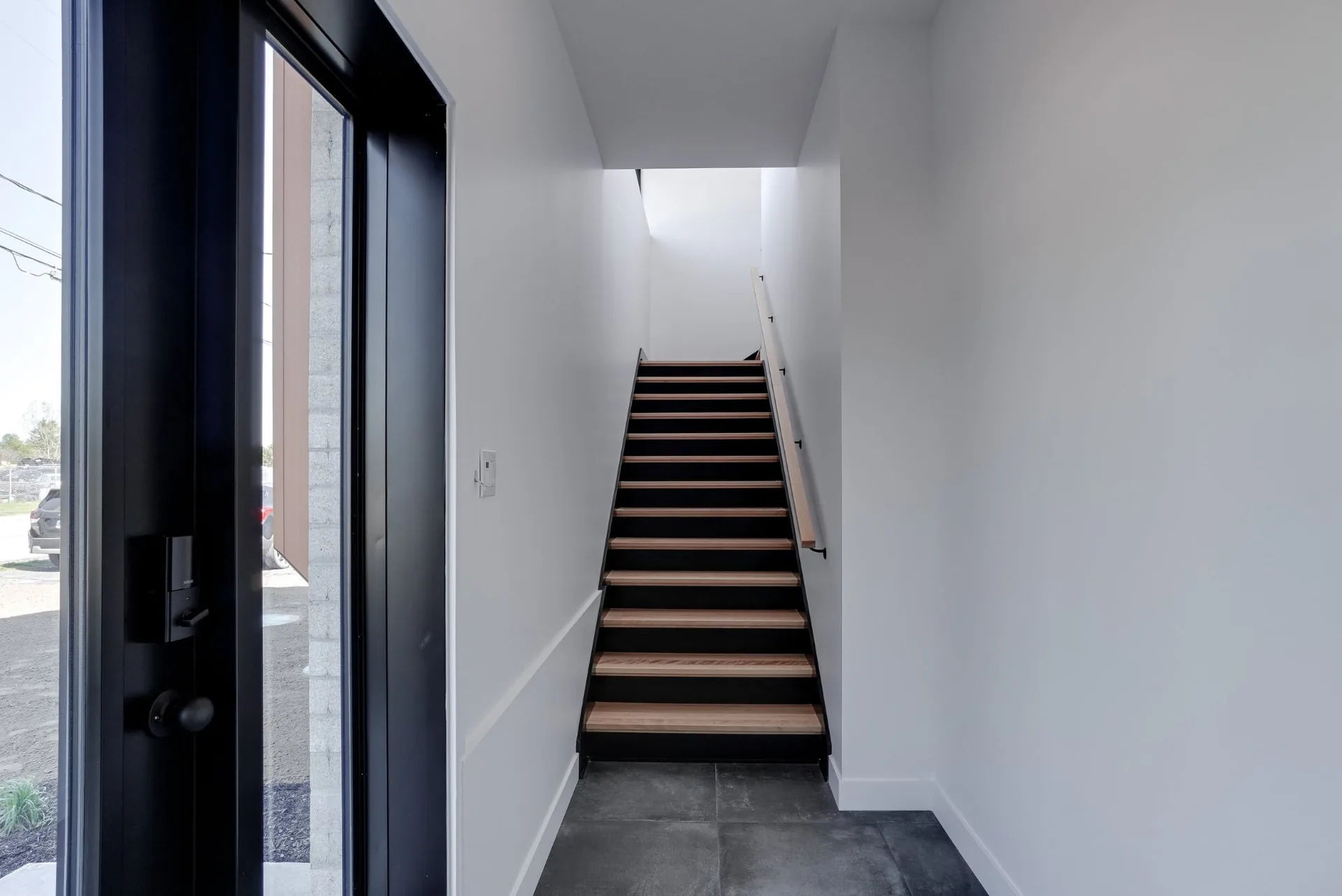 L’entrée vitrée et l’escalier menant aux bureaux